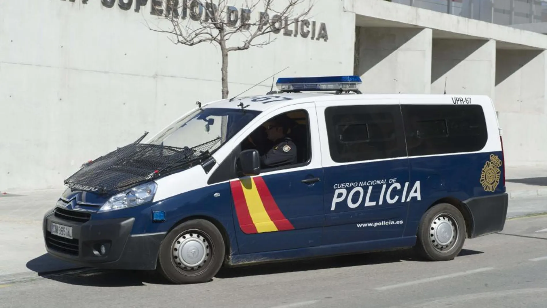 Un vehículo policial traslada a la Jefatura Superior de Policía de Granada a cinco personas por los cursos de formación