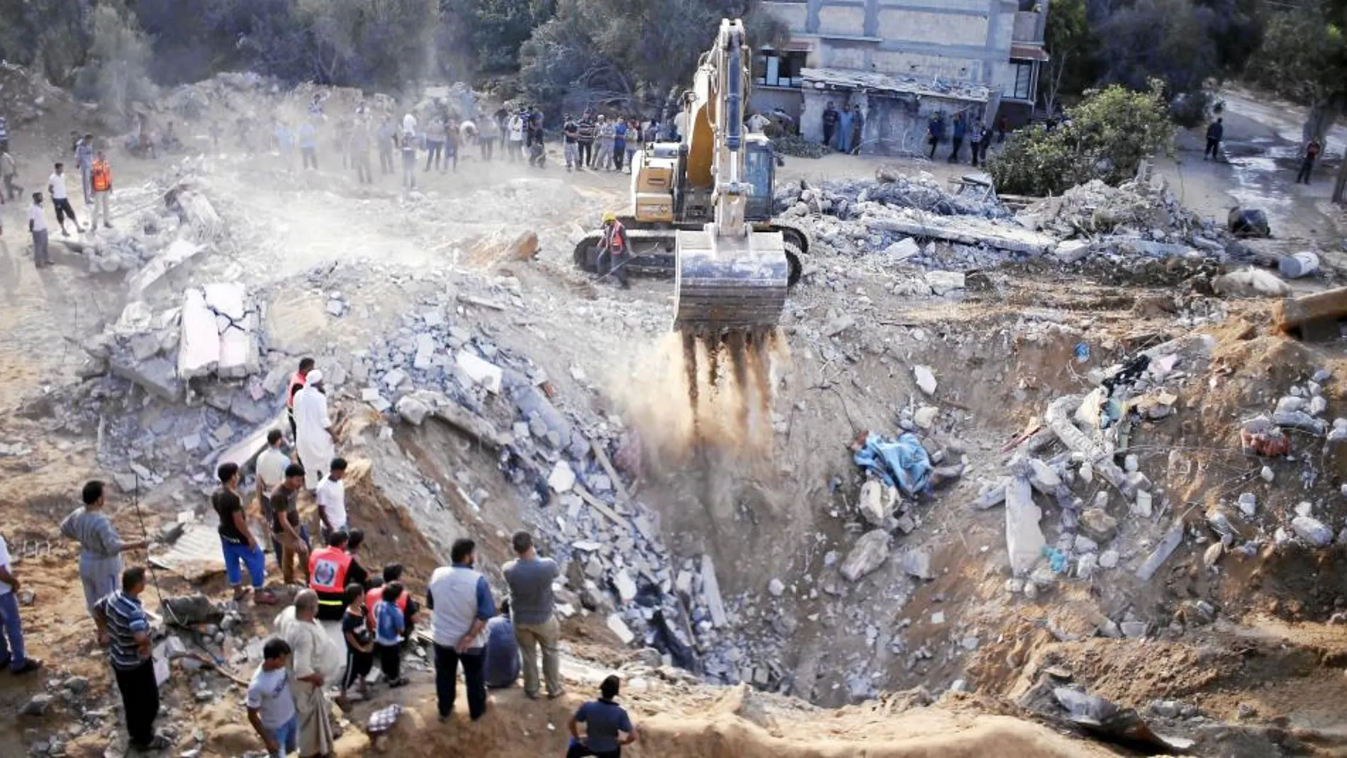 Una excavadora busca supervivientes en un edificio bombardeado por Israel en la localidad de Yan Yunis, al sur de Gaza