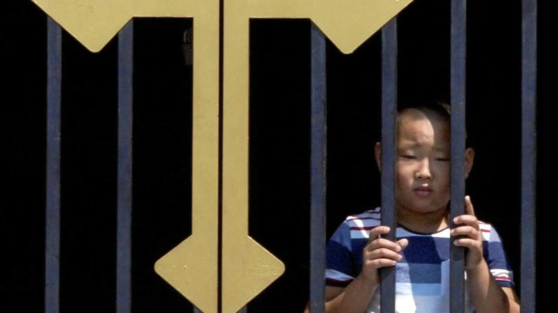 Un niño chino en la puerta principal de la iglesia católica de Wanfujing, en Pekín.
