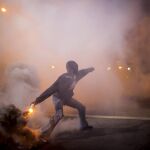 Un manifestante tira un bote de gas lacrimógeno arrojado por la policía en Baltimore