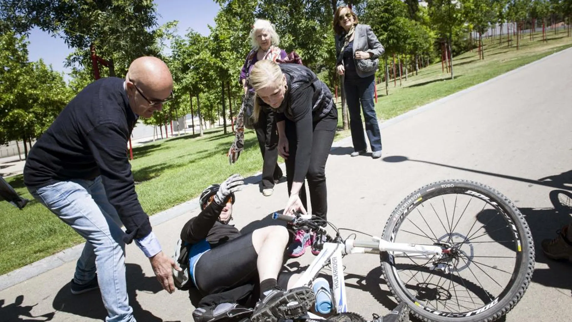 Cristina Cifuentes ayuda a un ciclista accidentado durante un paseo por el parque de Madrid Rio