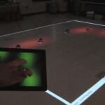 Un operador humano controlando los robots desde una tablet