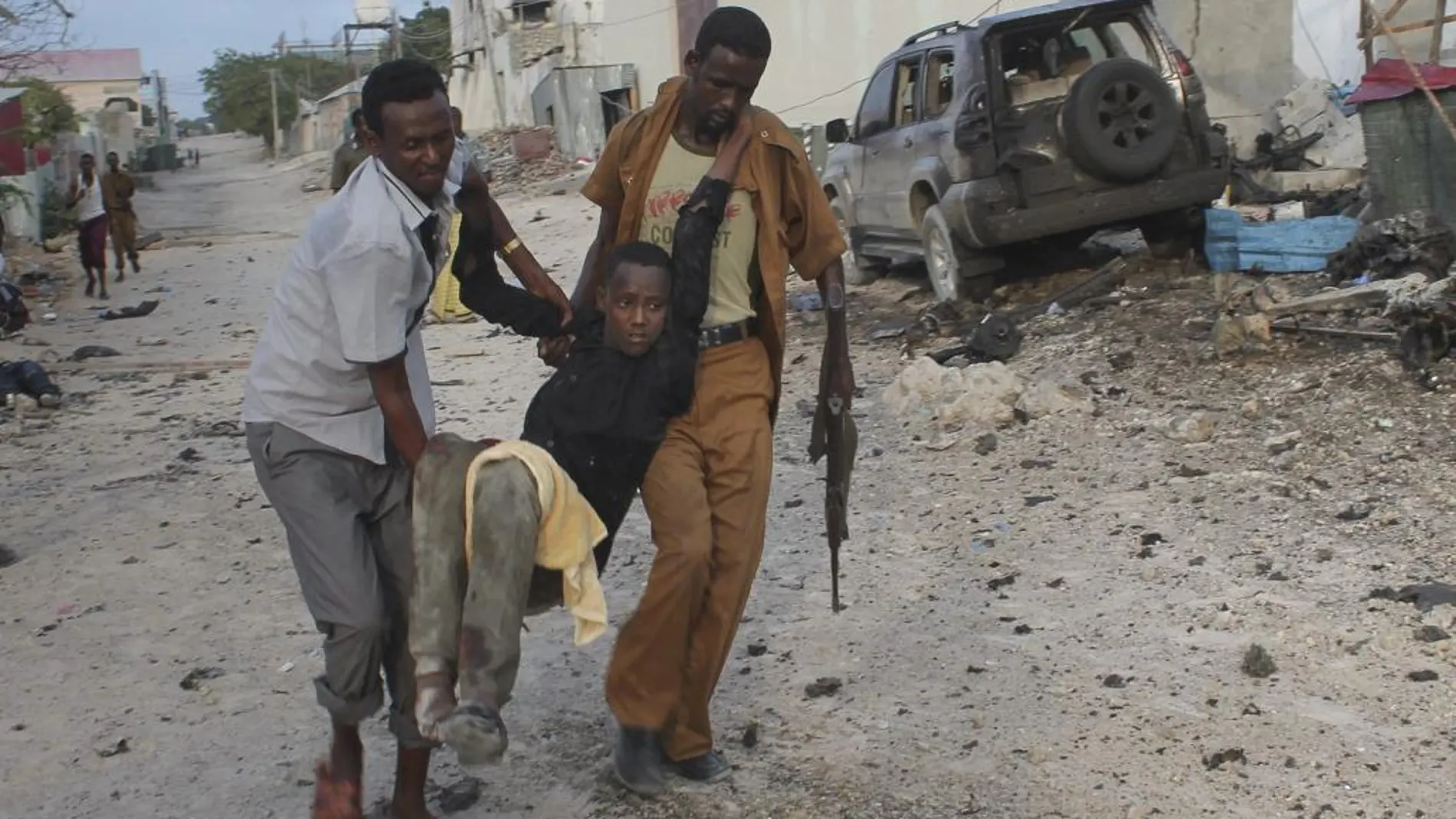 Un hombre herido es evacuado de la zona en la que se ha registrado la explosión de un coche bomba, en Mogadiscio, Somalia