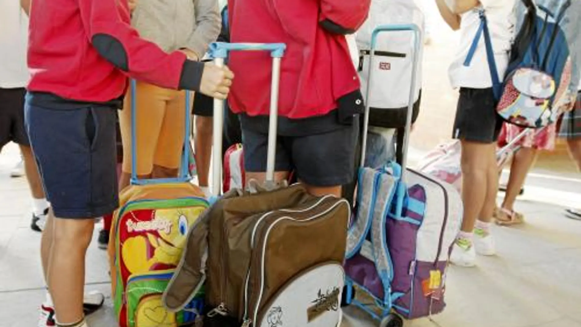 Niños aguardan en cola para entrar en sus aulas