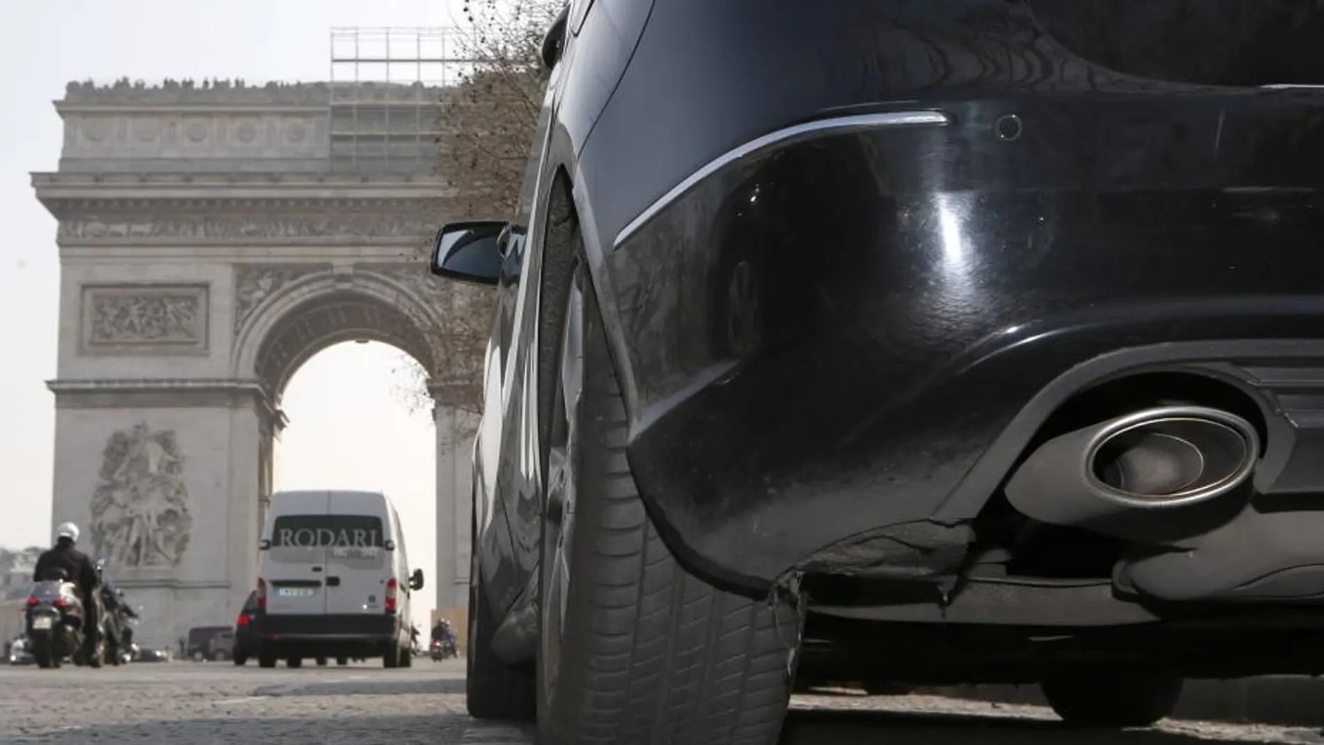 Un coche circula cerca del Arco del Triunfo