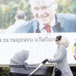 Una mujer pasea a su bebé frente a un cartel a favor del actual presidente de Croacia, Ivo Josipovic.