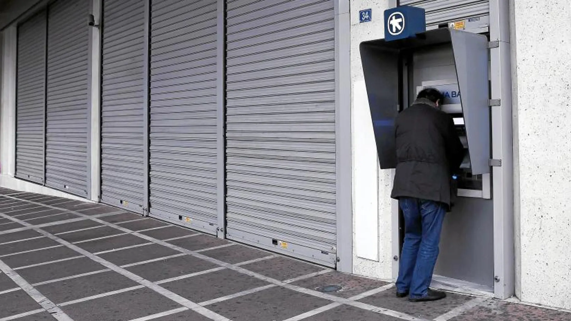 Un ciudadano griego saca dinero ayer en un cajero de Atenas