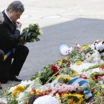 El presidento de Ucrania, Petro Poroshenko (a la derecha) y el embajador holandés, Kees Klompenhouwer, rinden homenaje a las víctimas del avión malasio junto a la legación de Holanda en Kiev.