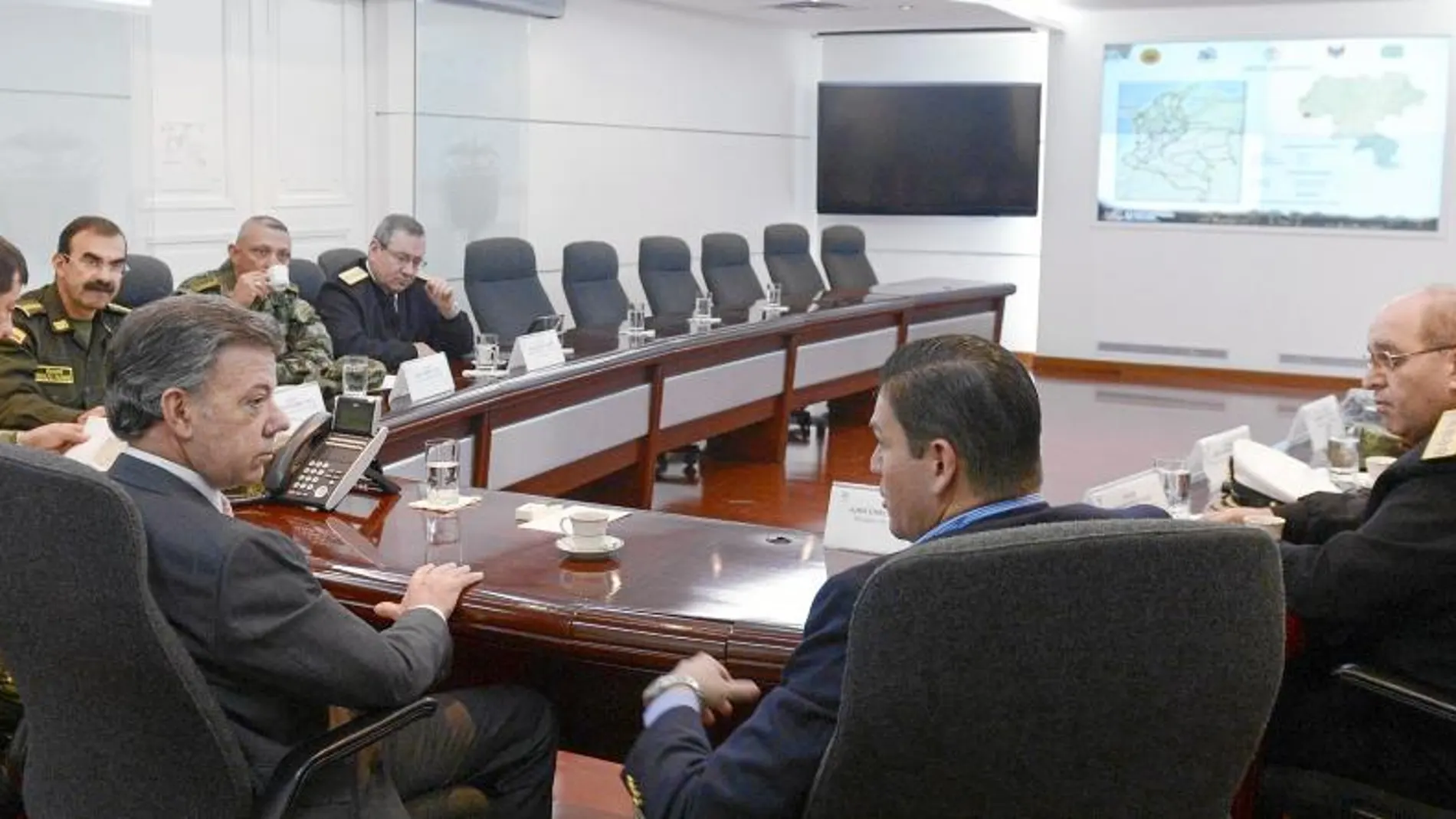 El presidente Santos escucha a su ministro de Defensa en presencia de altos cargos militares, ayer
