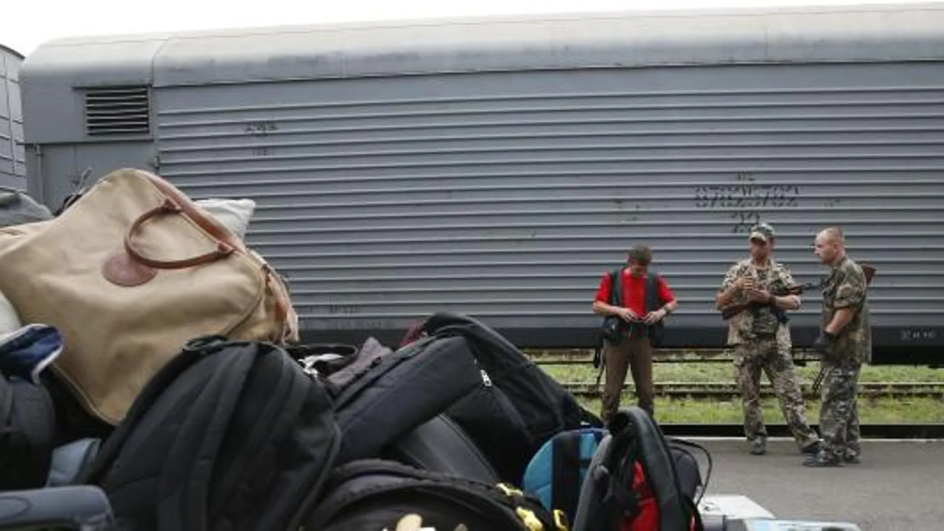 Separatistas prorrusos vigilan el tren que transporte los restos de las víctimas y los equipajes recogidos en el lugar del accidente.