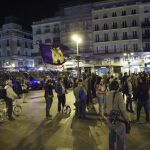Miembros del movimiento 15M, vigilados por policías nacionales, durante su grito silencioso de la noche del viernes en la madrileña Puerta del Sol