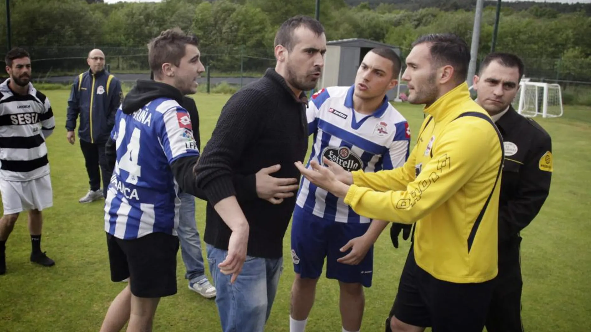 El jugador del Deportivo Lucas Pérez trata de calamar a uno de los seguidores deportivistas que hoy han interrumpido el entrenamiento