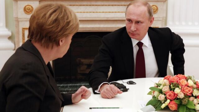 Vladimir Putin escucha a la canciller alemana, Angela Merkel