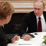 Vladimir Putin escucha a la canciller alemana, Angela Merkel