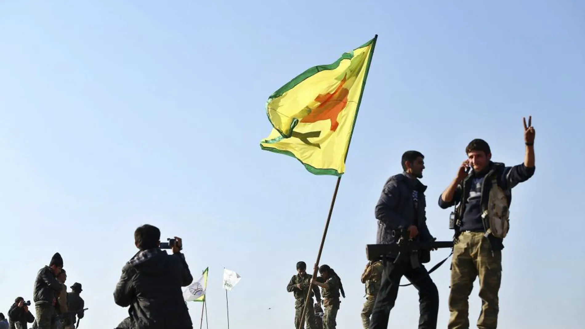 Varios miembros de las Unidades de Protección del Pueblo Kurdo (YPG) celebran su victoria en la ciudad de Kobani, Siria, ayer lunes