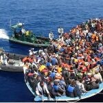 Los inmigrantes junto a la embarcación de la Guardia Civil