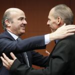 El ministro español de Economía, Luis de Guindos, saluda al ministro griego de Finanzas, Yanis Varoufakis (dcha), durante la reunión del Eurogrupo.
