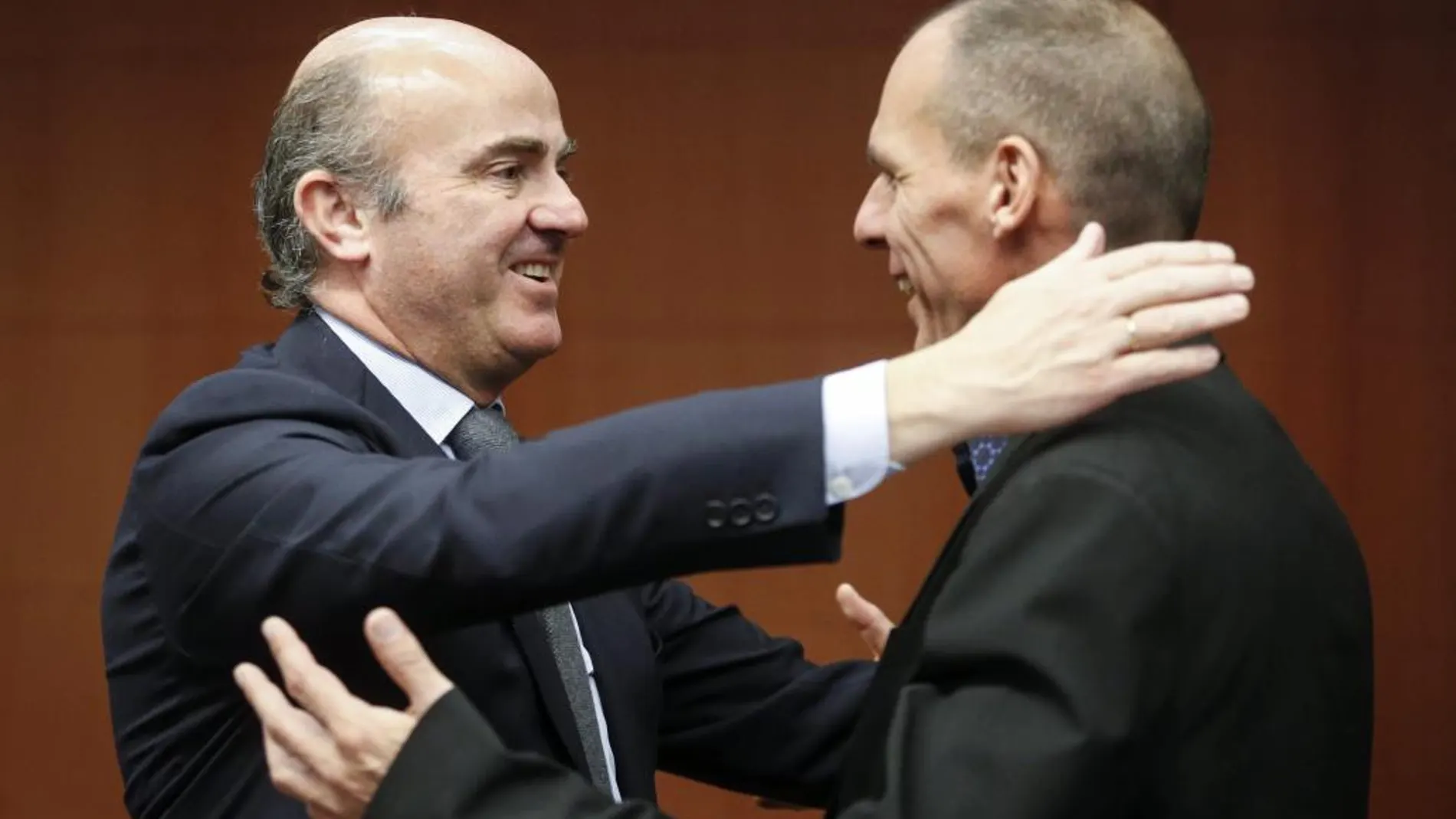 El ministro español de Economía, Luis de Guindos, saluda al ministro griego de Finanzas, Yanis Varoufakis (dcha), durante la reunión del Eurogrupo.