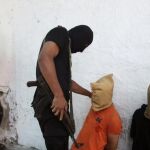 Los militantes de hamas junto a uno de los palestinos a los que ha ejecutado