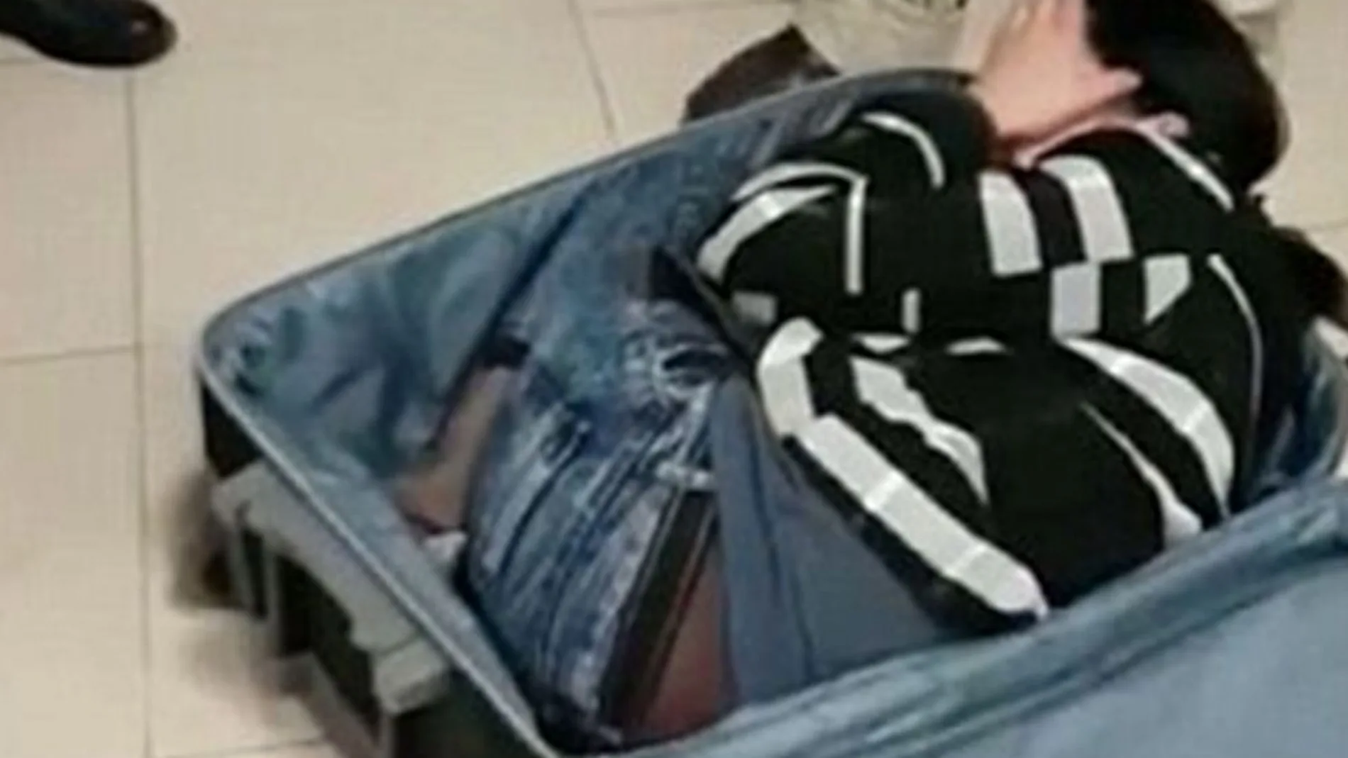 Imagen del momento en el que los funcionarios descubren el contenido de la maleta