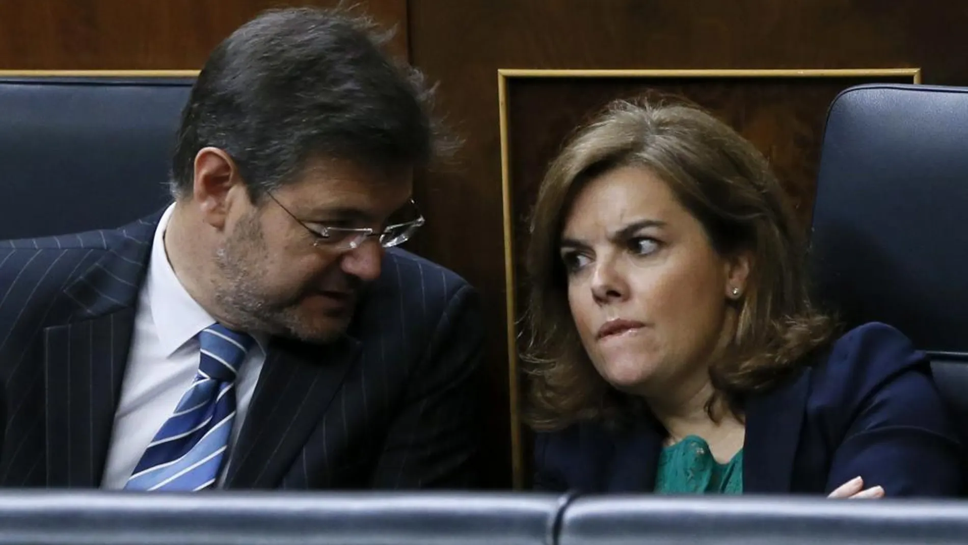 La vicepresidenta del Gobierno, Soraya Sáenz de Santamaría, conversa con el ministro de Justicia, Rafael Catalá, durante la sesión de control al Ejecutivo