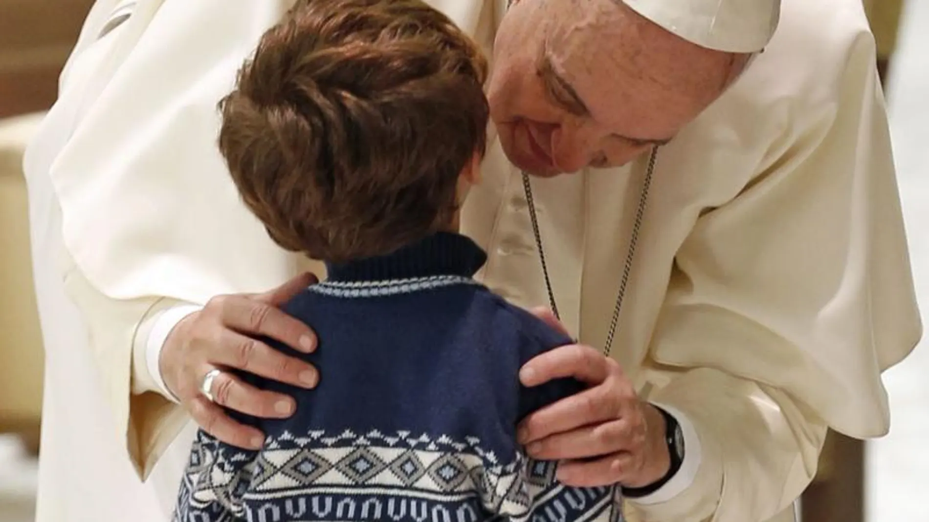 El Papa besa a un niño durante el encuentro con las familias