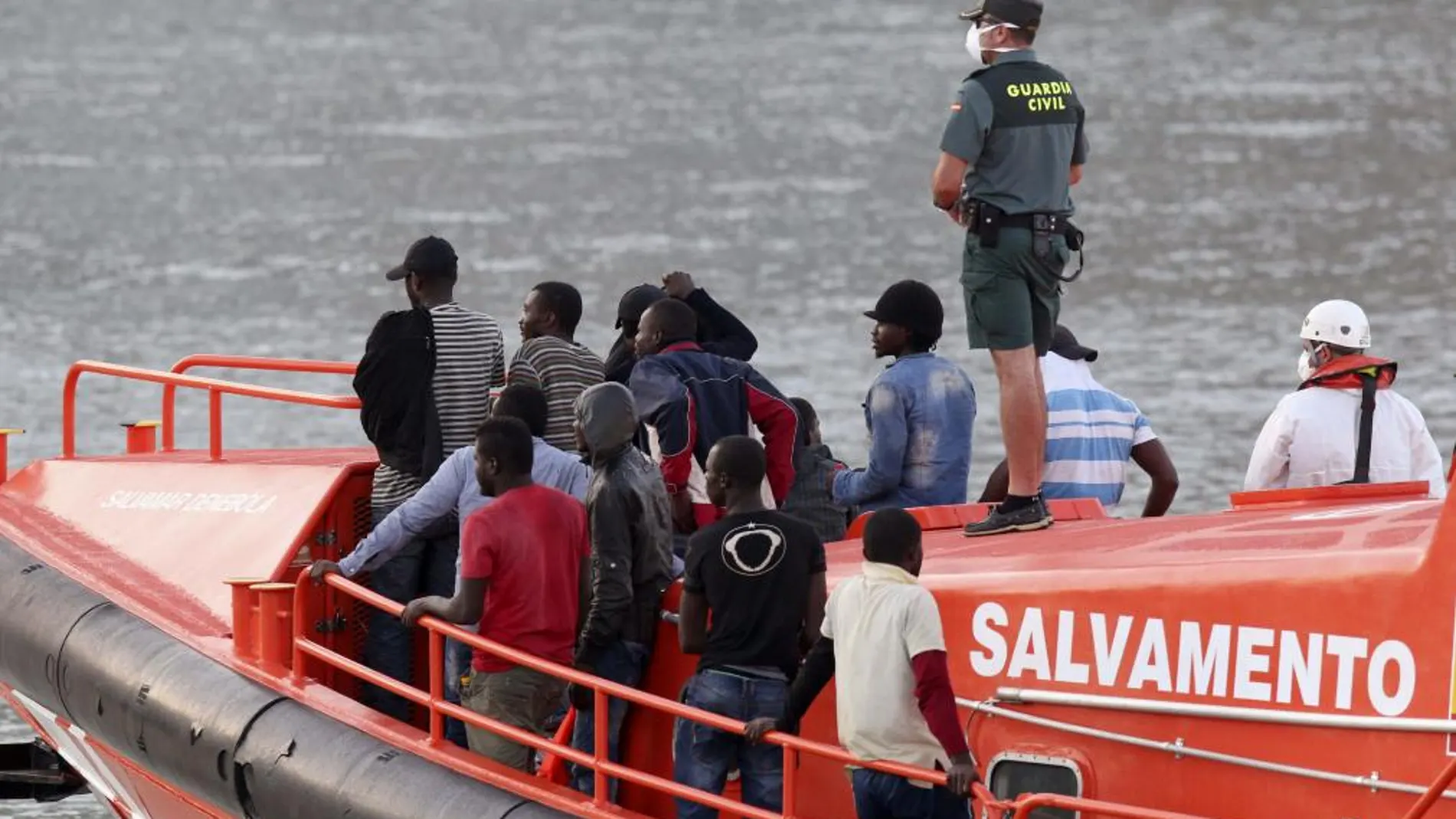 Efectivos de Salvamento Marítimo y la Guardia Civil trasladan a inmigrantes en una imagen de archivo