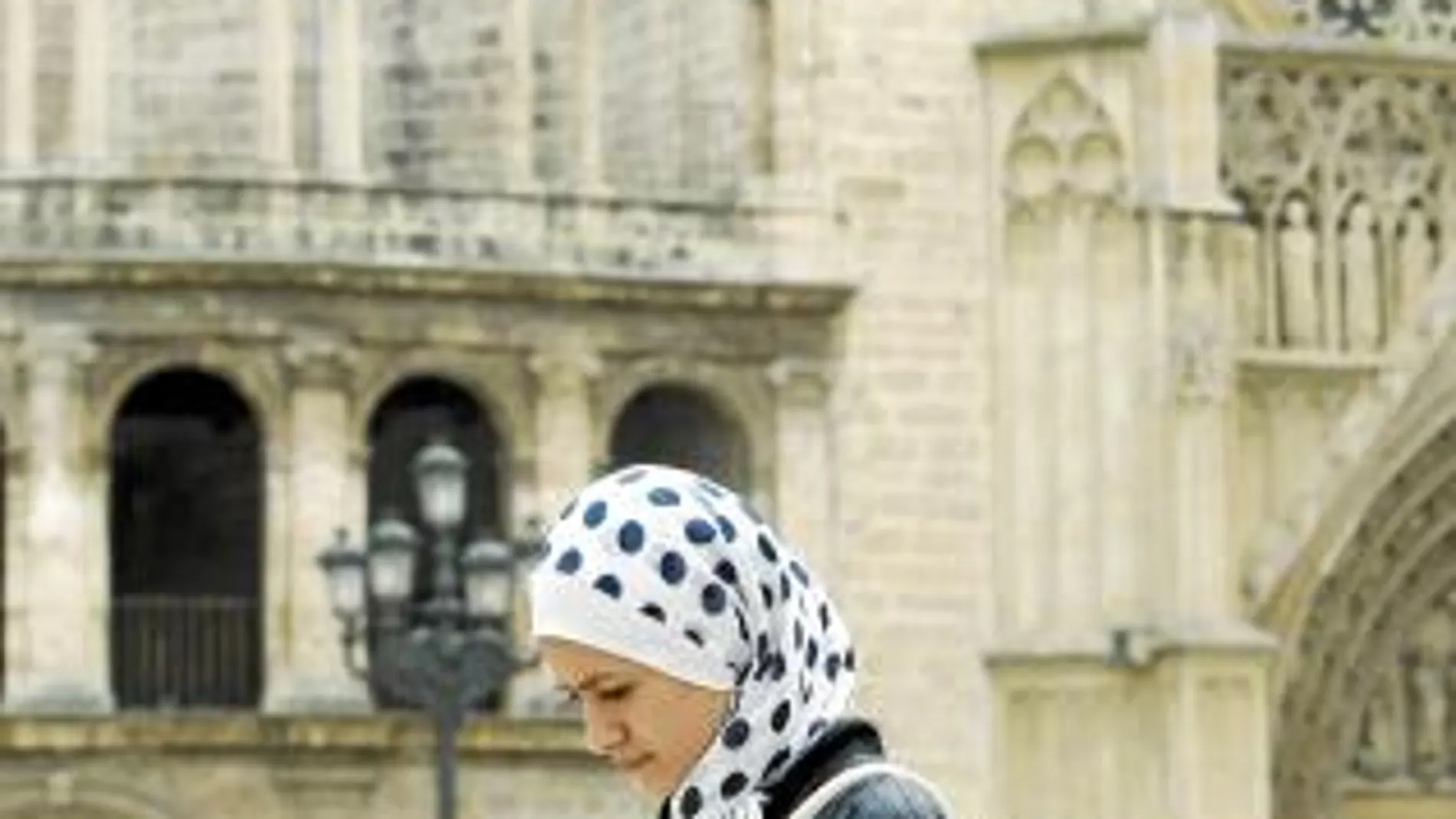 Una joven musulmana pasea con el «hiyab» puesto frente a la catedral de Valencia