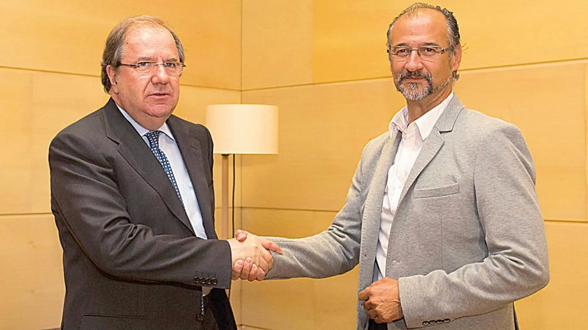 El presidente del PP, Juan Vicente Herrera, y el delegado autonómico de Ciudadanos, Luis Fuentes, estrechan sus manos antes de firmar el compromiso