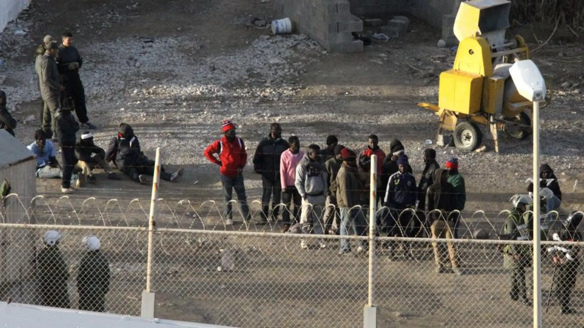 Imagen de archivo de Inmigrantes subsaharianos rodeados por la Policía marroquí, en el perímetro fronterizo entre Ceuta y Marruecos