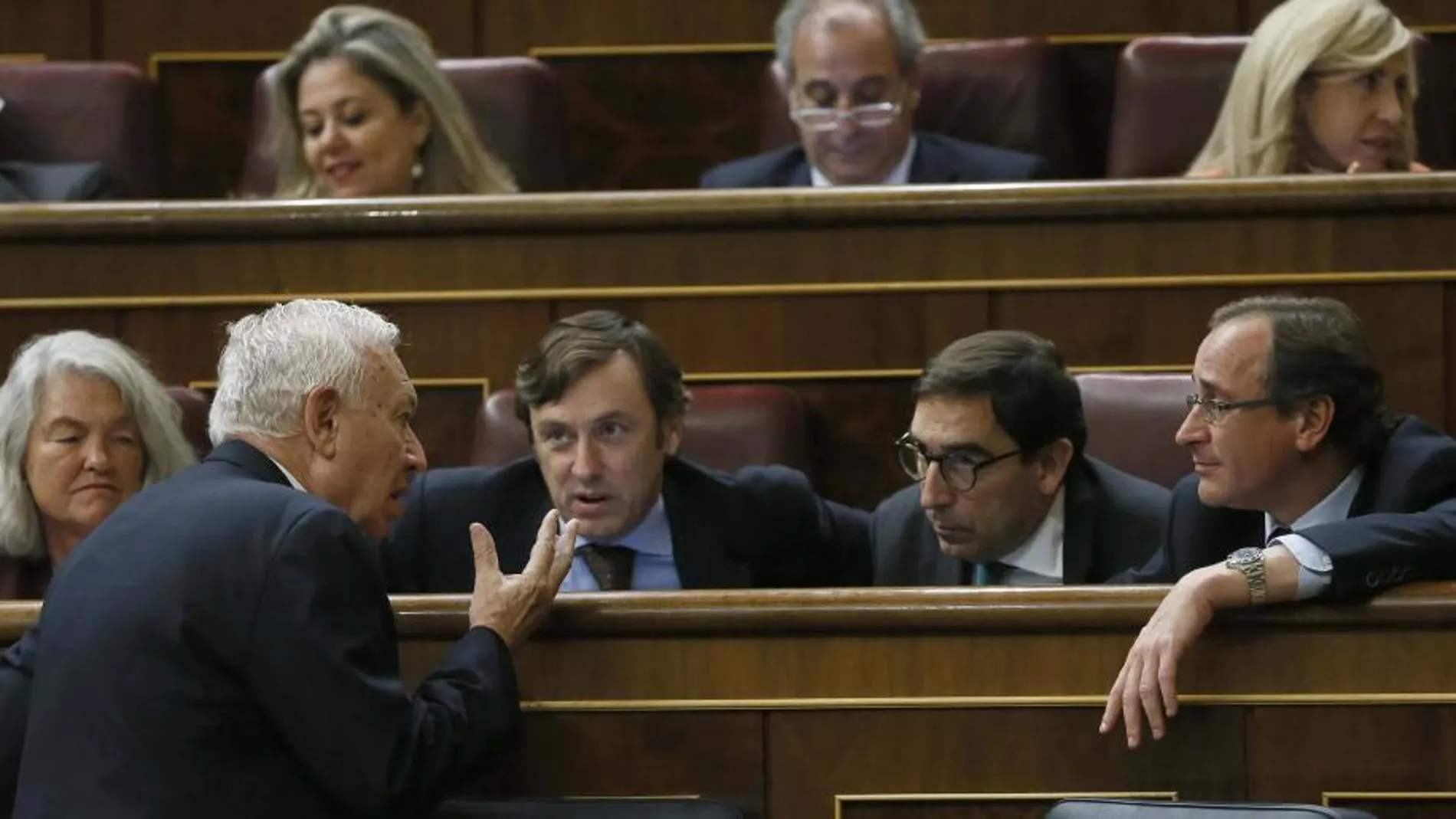 El ministro de Asuntos Exteriores, José Manuel García-Margallo (i), conversa con el portavoz del PP en el Congreso, Alfonso Alonso (d), y el diputado Rafael Hernando (2i), entre otros, durante la sesión plenaria.