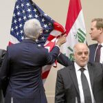 John Kerry, secretario de Estado de EE UU, coloca las banderas en su reunión ayer en Bruselas con el primer ministro iraquí, Al Abadi (centro). Abajo, varios «peshmerga» vigilan en Makhmur, al sur de Erbil.