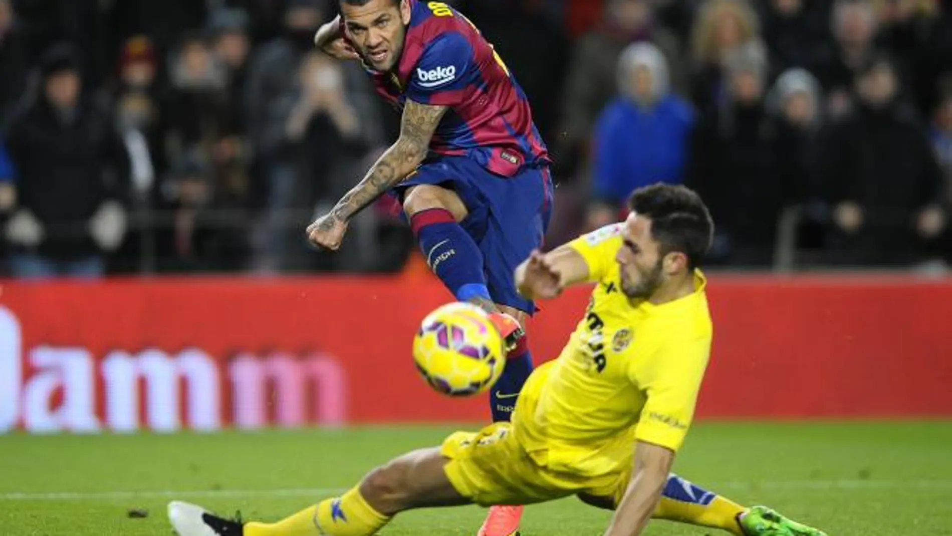 Dani Alves chuta, pese a la opsición del jugador del Villarreal Victor Ruiz