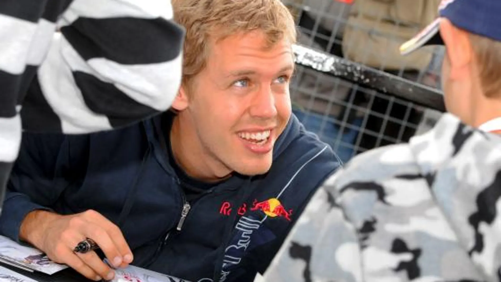 El piloto alemán Sebastian Vettel, de la escudería Red Bull, firma autógrafos después de la sesión de clasificación del Gran Premio de Gran Bretaña de Fórmula Uno