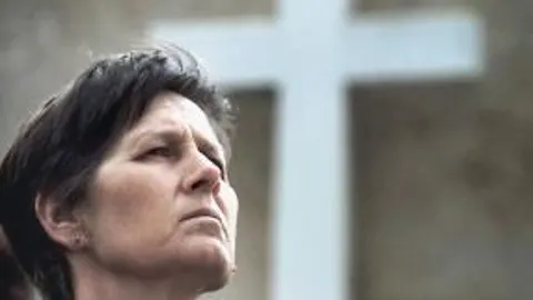 Una mujer en pleno rezo del rosario