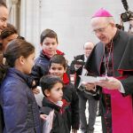 El arzobispo de Madrid, Carlos Osoro, bendice a una de las muchas familias que se acercaron a la Catedral de la Almudena