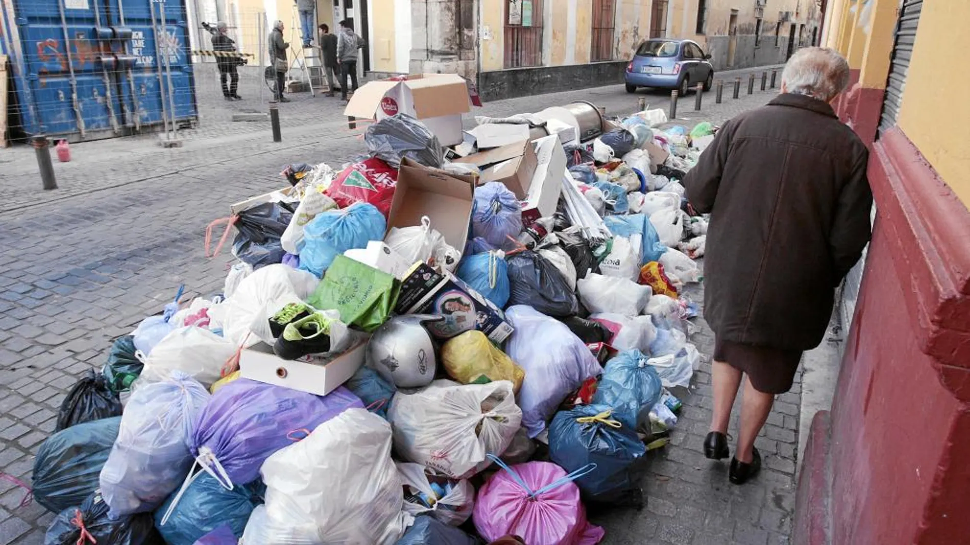 Una mujer trata de sortear en el Pumarejo los desperdicios que ocupan la acera