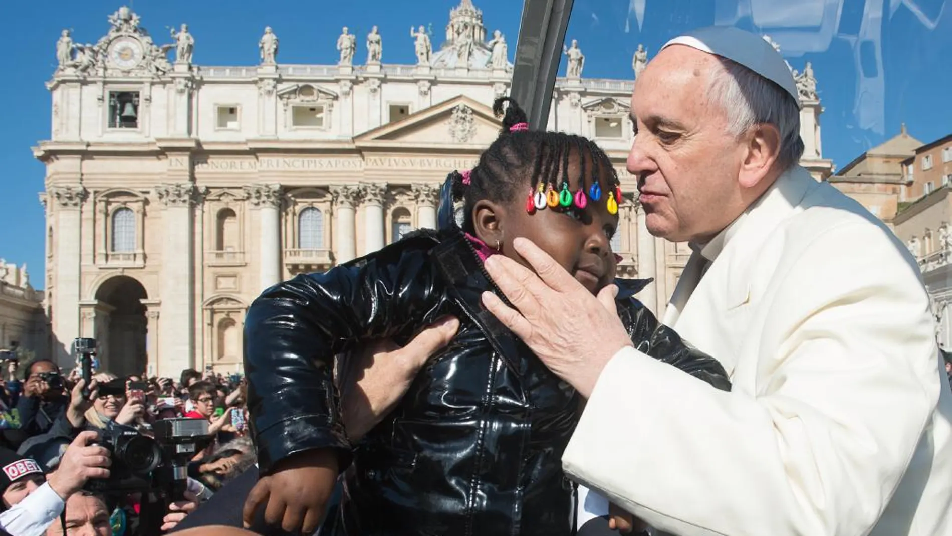 Francisco besa a una niña en el Vaticano