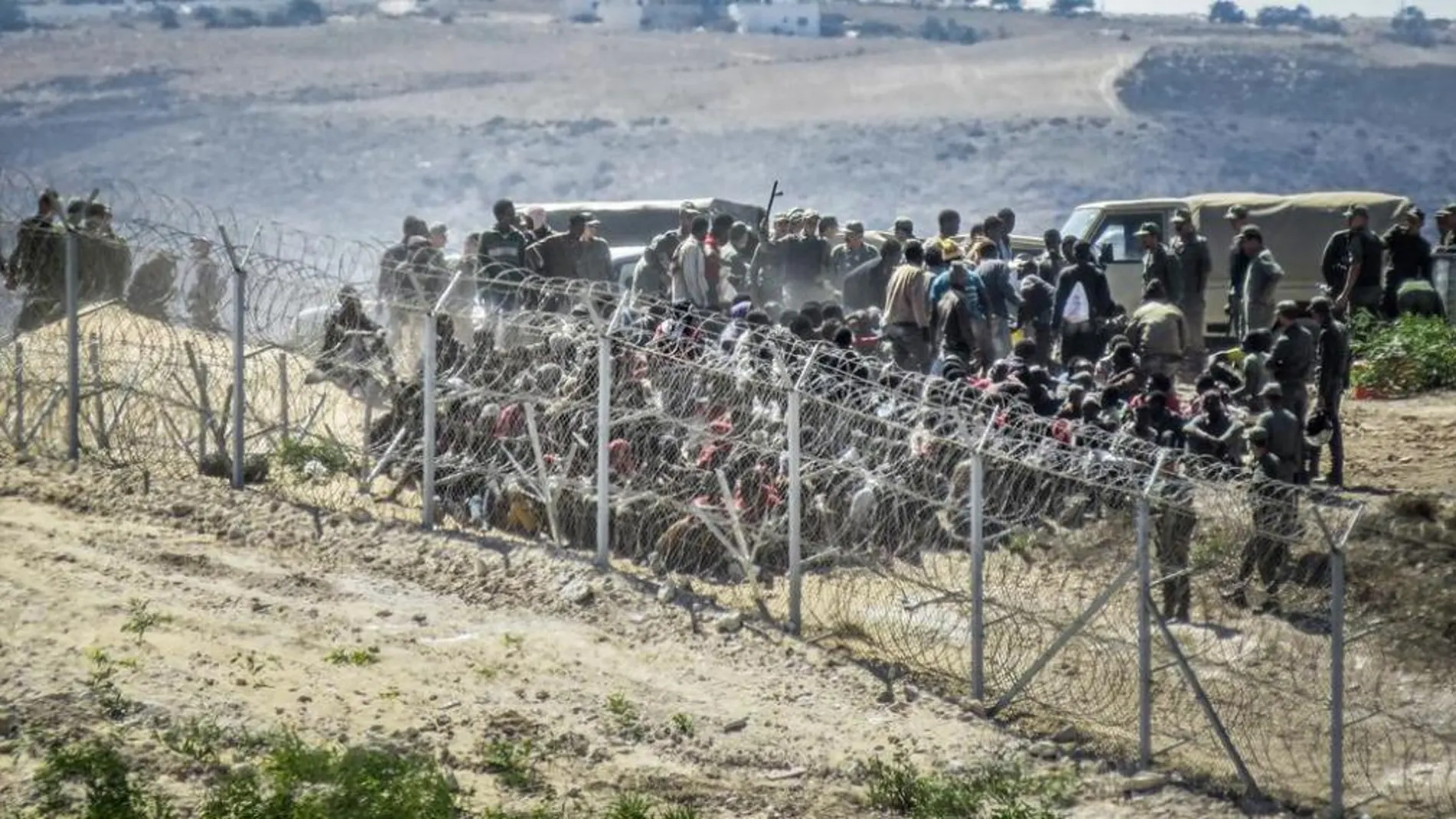 Los inmigrantes junto a la valla