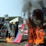 Activistas surcoreanos queman banderas y retratos del líder norcoreano, Kim Jong-Il, durante una manifestación contra Corea del Norte