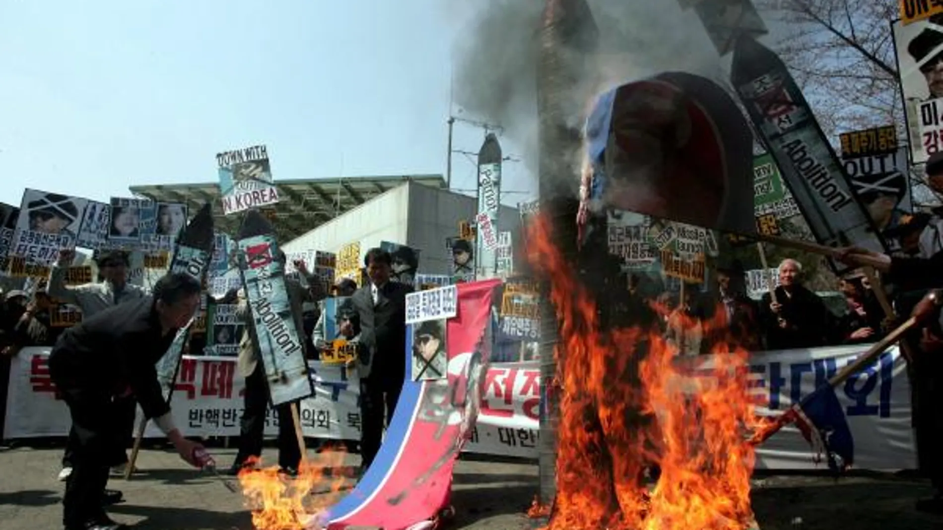 Activistas surcoreanos queman banderas y retratos del líder norcoreano, Kim Jong-Il, durante una manifestación contra Corea del Norte