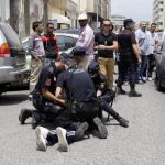 Varios policías reducen a una persona ante la sede de Correos de Melilla, en la que los agentes han tenido que intervenir después de que se haya registrado un altercado entre simpatizantes de Coalición por Melilla (CPM) y miembros del PP