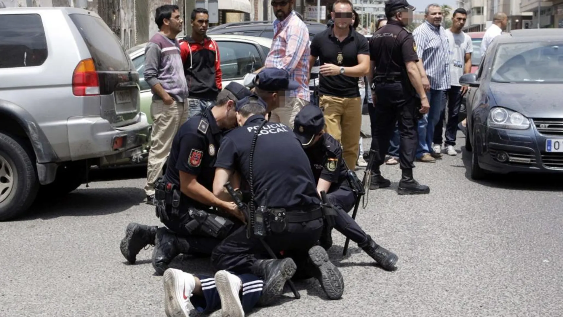 Varios policías reducen a una persona ante la sede de Correos de Melilla, en la que los agentes han tenido que intervenir después de que se haya registrado un altercado entre simpatizantes de Coalición por Melilla (CPM) y miembros del PP