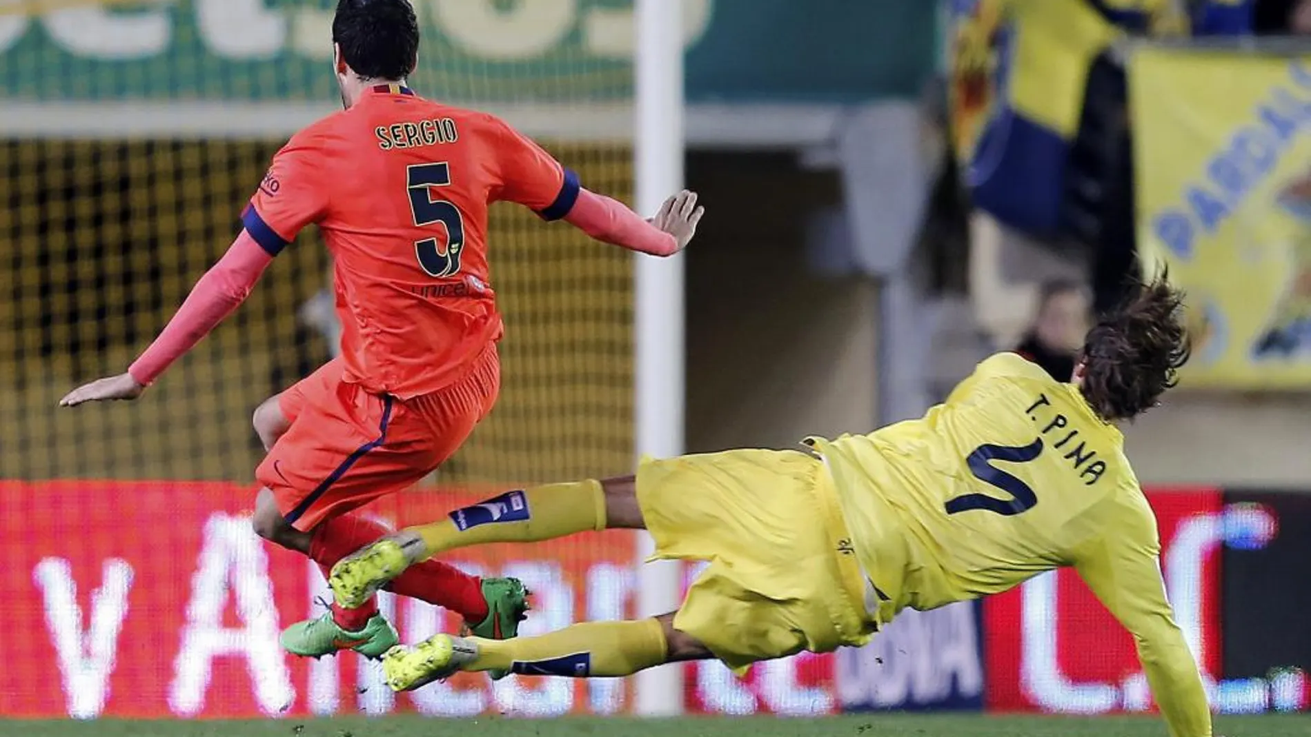 El centrocampista del FC Barcelona Sergio Busquets cae lesionado tras la entrada de Tomás Pina, centrocampista del Villarreal