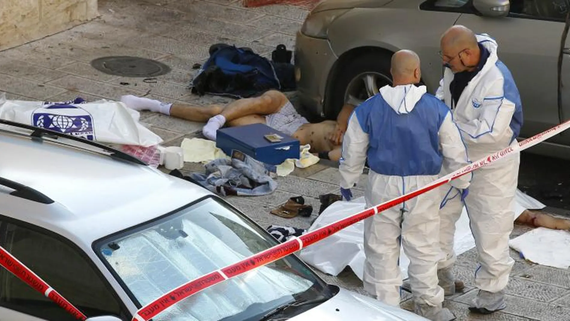 Investigadores de la policía, en el lugar del ataque junto a los cuerpos de los atacantes