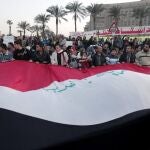 Unos manifestantes sostienen una gran bandera egipcia en la plaza Tahrir de El Cairo, Egipto, durante una multitudinaria protesta coincidiendo con el segundo aniversario de la revolución que derrocó a Hosni Mubarak