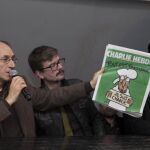 El nuevo redactor jefe de del semanario satírico francés "Charlie Hebdo", Gerard Biard (2i) el caricaturista Luz (C), el periodista Patrick Pelloux (3d) y el redactor jefe del periódico Liberation Laurent Joffrin (2d) muestran la portada de la revista durante una rueda de prensa celebrada en París, el pasado 13 de enero