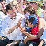 Rajoy, ayer, juega con el hijo de Alicia Sánchez Camacho
