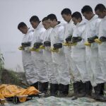 Miembros de los servicios de rescate guardan un minuto de silencio en respeto a las víctimas del barco de pasajeros naufragado en el río Yantsé en China