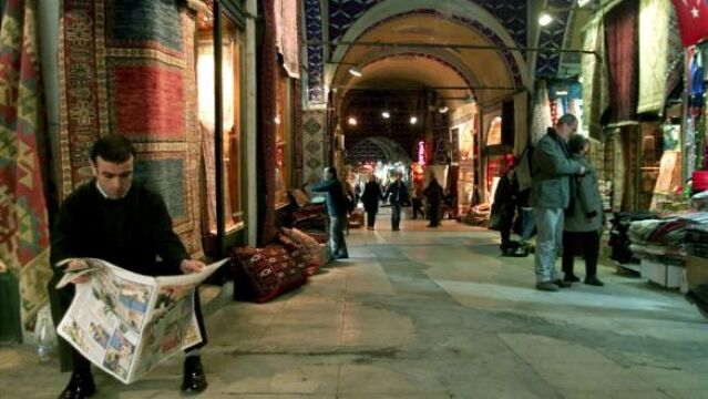 Un dependiente turco lee la prensa en un mercado de Estambul